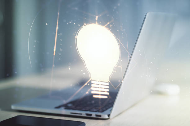 istock Creative light bulb hologram on modern laptop background, idea concept. Multiexposure 1328654041