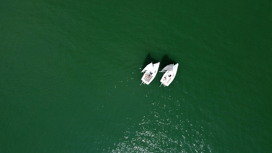 Aerial drone view of sailing boat on a river.