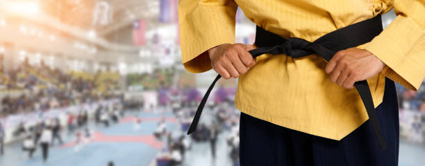 мастер черный пояс taekwondo учитель держит и завязывает пояс поза - do kwon стоковые фото и изображения