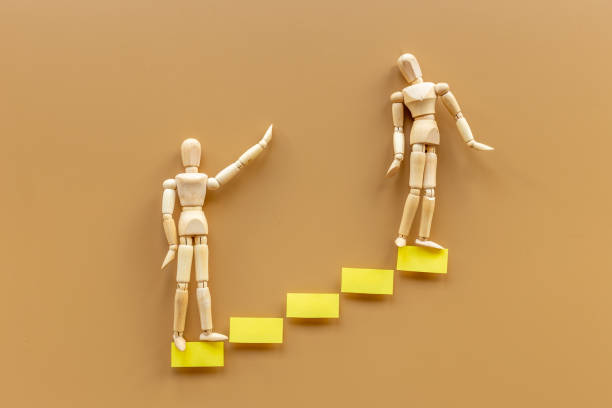 istock Two human mannequin figure on stairs. Helping partner teambuilding leadership concept 1328660439