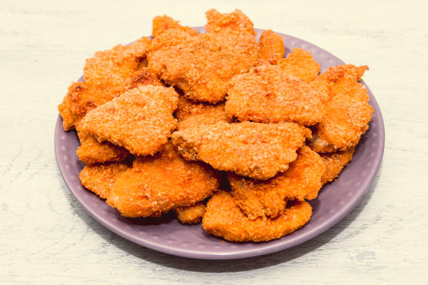 istock on the kitchen white table fried chicken strips in breaded prepared in the home kitchen. close up 1328663967