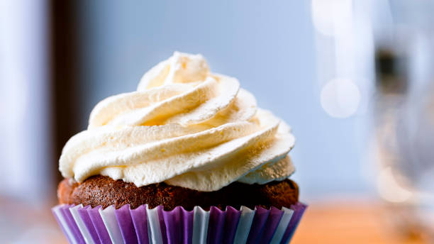 Chocolate cupcake with white cream Close-up of chocolate cupcake with white whipped cream. cream cake stock pictures, royalty-free photos & images