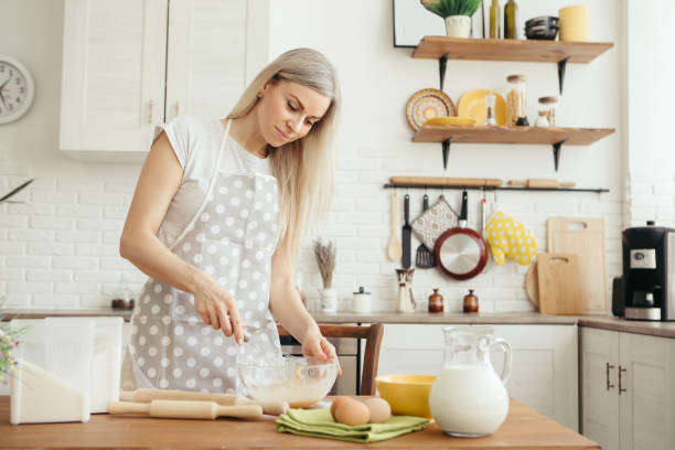 istock Young beautiful woman kneads dough for baking cookies 1328668238