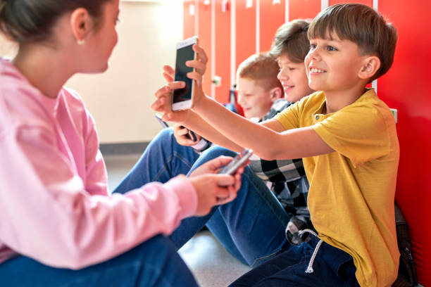 istock School children sitting on the floor and using smartphone 1328669450