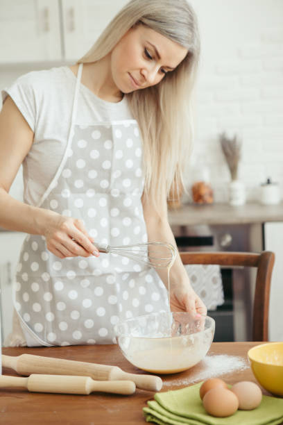 istock Young beautiful woman kneads dough for baking cookies 1328670972