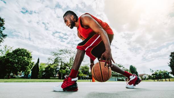 jugador de baloncesto callejero driblando con pelota en la cancha - streetball, basket ball, entrenamiento y concepto deportivo - dribbling fotografías e imágenes de stock