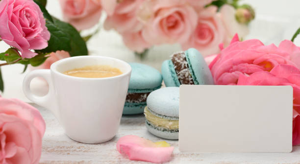 istock blank white business card and cup with espresso coffee and white ceramic cup with coffee and blue macaron on a white table, 1328673461