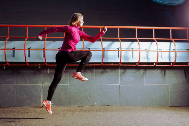 istock Professional Senior Female Runner in Jogging Outfit During Running Training in Evening City Environment. Horizontal Image Composition 1328673473