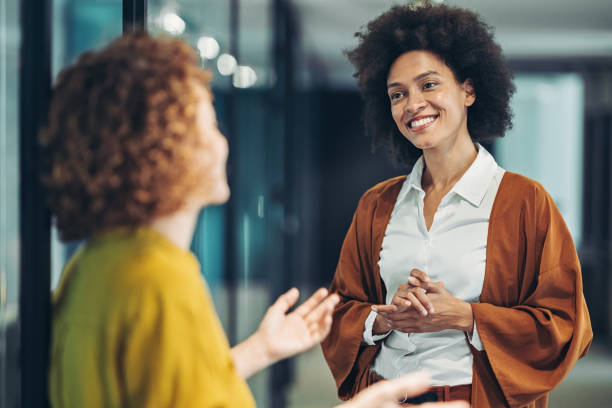 istock Two businesswomen talking in the corridor 1328677026