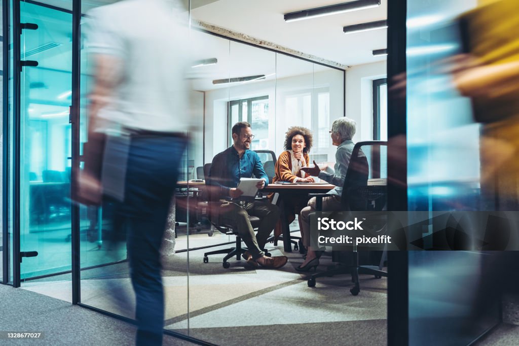 Busy day in the office Group of business persons having a meeting in a closed glass conference room Teamwork Stock Photo
