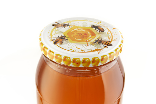 Honey bee in a jar on a white background