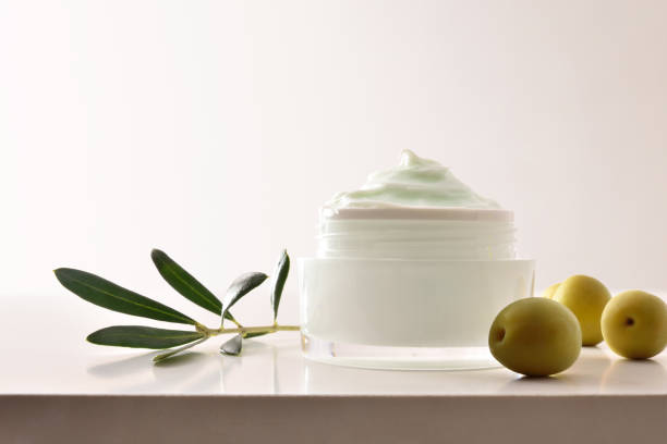 istock Olive moisturizing cream for skin on white table front 1328679968