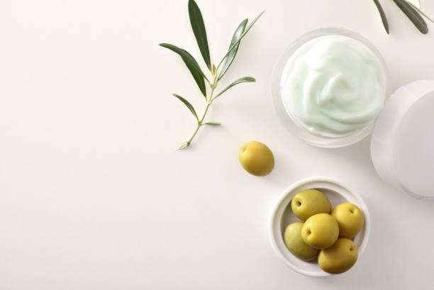 istock Olive moisturizing cream for skin on white table top 1328679971