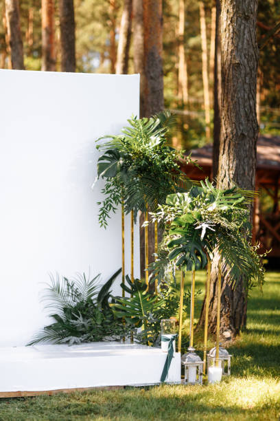 istock Wedding decorations in luxury ceremony. Arch for wedding ceremony a is decorated with flowers and greens, greenery. wedding decor outdoors in the forest on summer sunny day. 1328681009