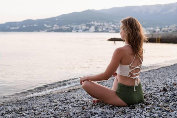 istock young woman meditating on the beach 1328682458