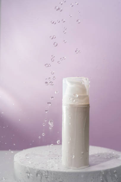 istock Cosmetic bottle with water splashes on a purple background. 1328682518