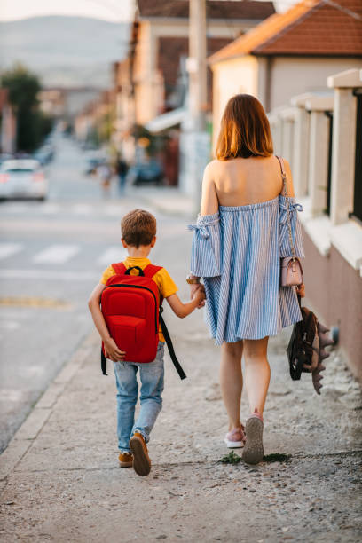 istock Mother walking her son to school 1328682873