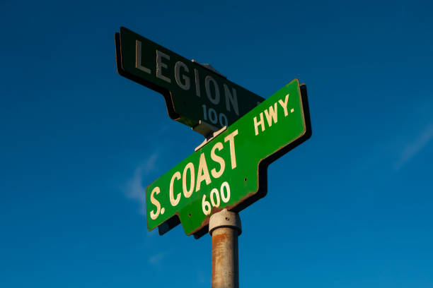 a placa verde da south coast highway, no sul da califórnia, fotografada ao pôr do sol com um fundo de céu claro. - california highway 1 - fotografias e filmes do acervo