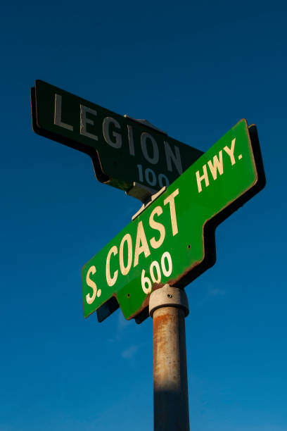 das grüne straßenschild für den south coast highway in südkalifornien, fotografiert bei sonnenuntergang mit klarem himmelshintergrund. - main street road sign street name sign clear sky stock-fotos und bilder