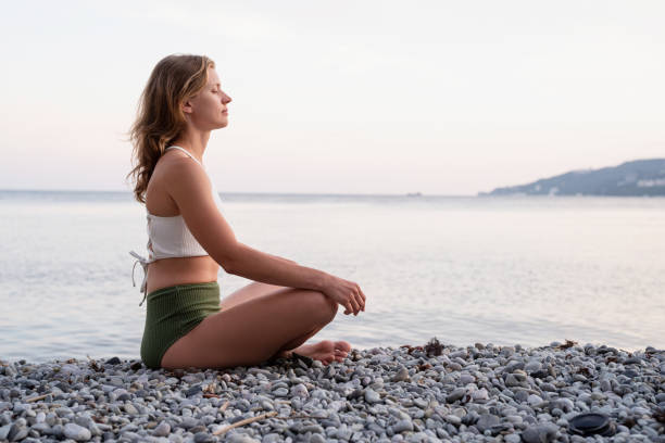 istock young woman meditating on the beach 1328684840