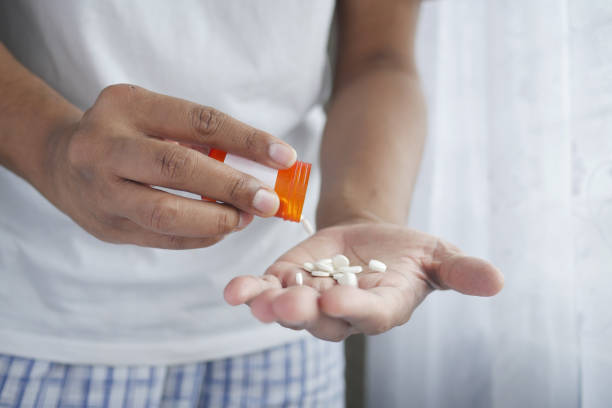 istock man's hand with medicine spilled out of the pill container 1328687314