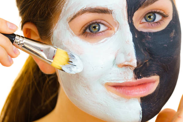 istock Girl black mask on half face apply white mud 1328689700