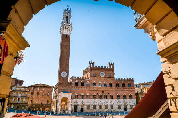 una vista sugerente de la piazza del campo en siena con la majestuosa fachada del palazzo pubblico y la torre del mangia - torre del mangia fotografías e imágenes de stock