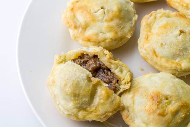 istock Steak pies on a plate - mini beef pies on white background with copy space - top view 1328692109