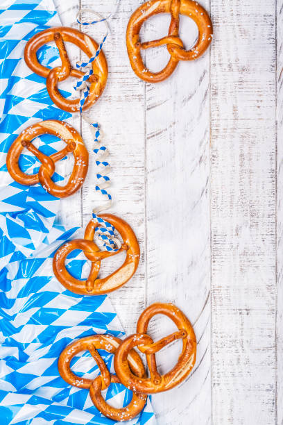 Beer Fest salted pretzels on white Freshly baked homemade soft pretzel with salt on white wooden table covered traditional blue and white Beer Fest tablecloth. Beer Fest food. Copy space oktoberfest food stock pictures, royalty-free photos & images