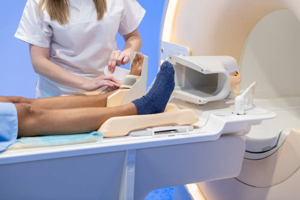 Technicians Preparing Female Patient For Leg MRI Scan. Magnetic resonance imaging technology in specialized medical clinic.