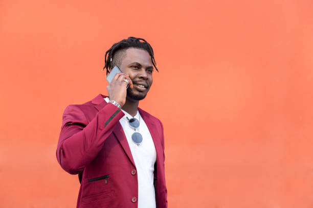 istock stylish black man in suit talking on phone 1328699127