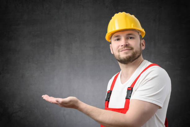 istock Worker looking at camera, and showing copy space with his hand 1328703175