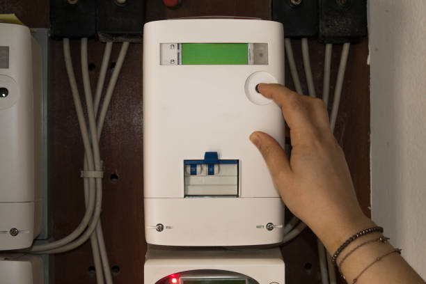 mulher verifica consumo de energia em um medidor de eletricidade - instrument of measurement meter voltmeter electric meter - fotografias e filmes do acervo