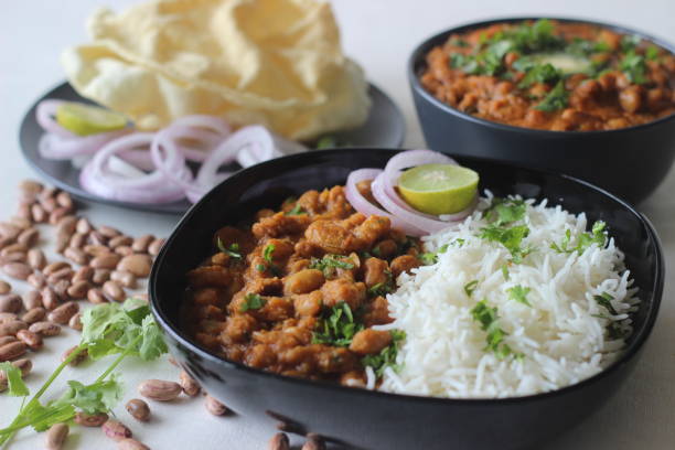 Red kidney beans in a thick and spicy gravy of onions and tomatoes served along with steamed basmati rice and papad. Commonly known as rajma masala and chawal in the northern parts of India. Red kidney beans in a thick and spicy gravy of onions and tomatoes served along with steamed basmati rice and papad. Commonly known as rajma masala and chawal in the northern parts of India. Shot on white background. garlic bulb photos stock pictures, royalty-free photos & images