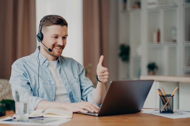 istock I like it. Glad bearded adult man has video conference keeps thumb up likes something focused at laptop computer has distance job interview dressed casually. Professional call center agent working 1328708676