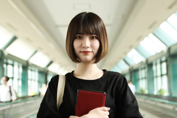 Young Asian Student Holding a Digital Tablet at University