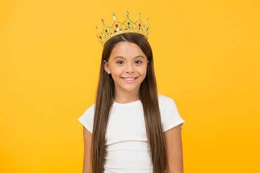 Become princess concept. Every girl dreaming to be princess. Lady little princess. Compelling baby. Kid wear golden crown symbol of princess. Girl cute baby wear crown while stand yellow background.