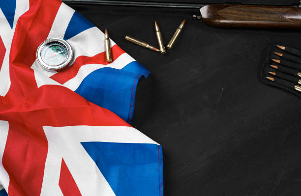 istock Union Jack flag with rifle and cartridges on black background 1328710556