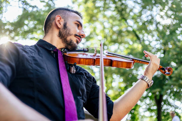 istock Man playing violin outdoors 1328711362