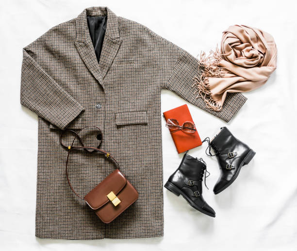 istock Women's autumn spring clothing  - oversized plaid coat, leather black boots, leather bag, beige cashmere scarf, sunglasses on a light background, top view 1328711575