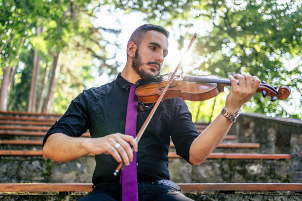 istock Man playing violin outdoors 1328711589