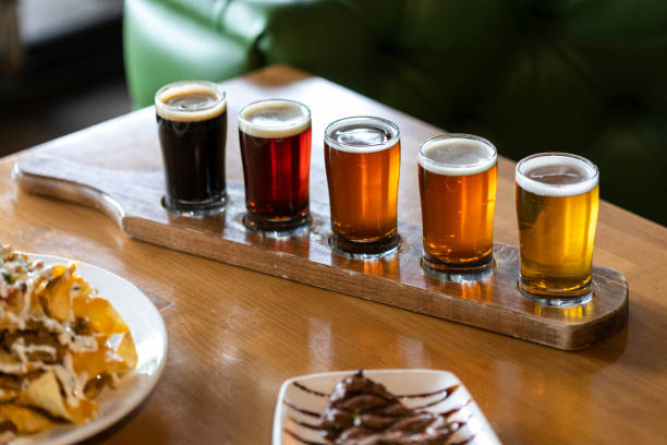 Flight of beers ranging in color from light to dark on wood carrier. Flight of beers ranging in color from light to dark on wood carrier. in Chandler, AZ, United States chandler arizona stock pictures, royalty-free photos & images