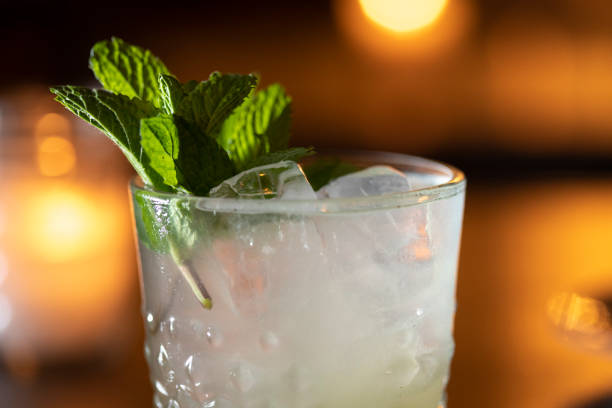 istock Top of cocktail garnished with fresh mint soft amber lights behind 1328711671