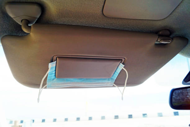 istock Medical mask under the visor in a car on a trip 1328711773