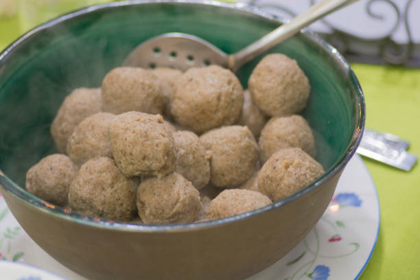 una ciotola di palline di matzah, o palline matzo, gnocchi di zuppa ebraica ashkenazi, tradizionalmente mangiati durante le festività ebraiche della pasqua ebraica - cooking close up matzo food foto e immagini stock