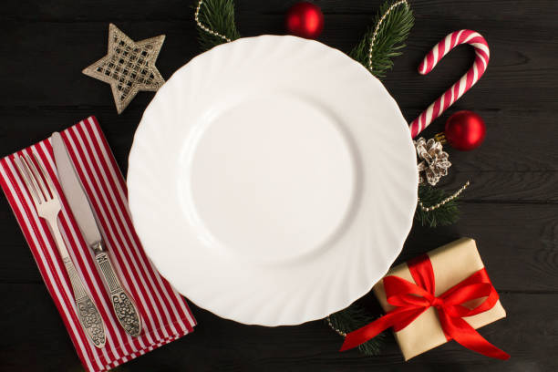 istock Empty white plate and Christmas composition on the black wooden background. Top view. 1328715490
