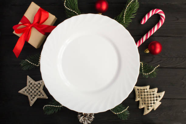 istock Empty white plate and Christmas composition on the black wooden background. Top view. 1328715507