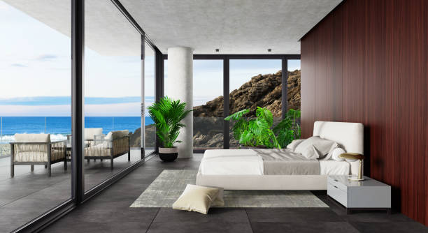 istock Luxury Hotel Modern interior bedroom with large windows. Spring scene ocean side with big rock. 1328718953