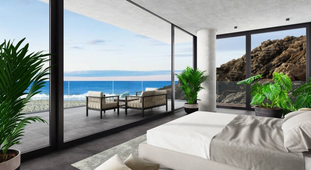 istock Luxury Hotel Modern interior bedroom with large windows. Spring scene ocean side with big rock. 1328718998