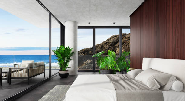 istock Luxury Hotel Modern interior bedroom with large windows. Spring scene ocean side with big rock. 1328719059
